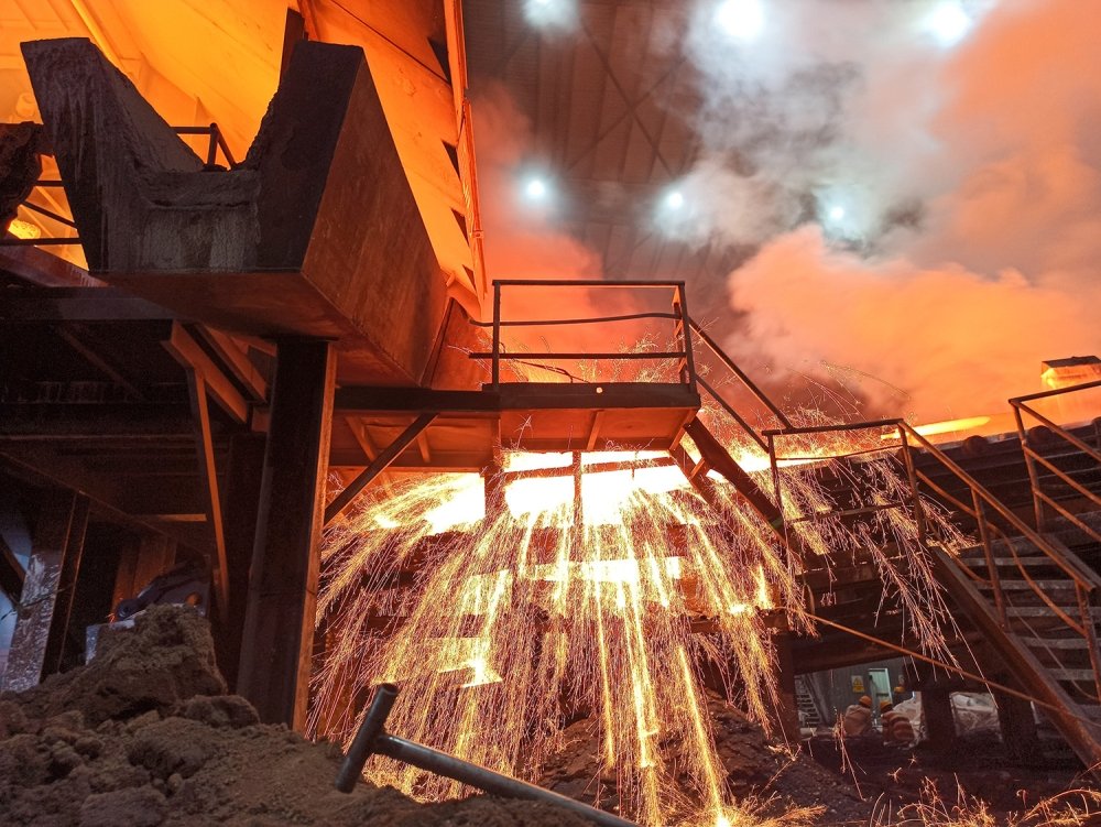 Sparks fly from a production smelter furnace.