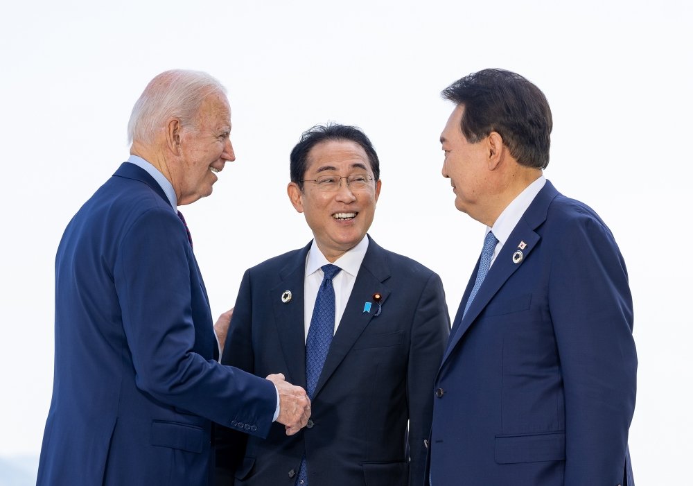 President Biden, Prime Minister Kishida, and President Yoon speaking casually at an event.