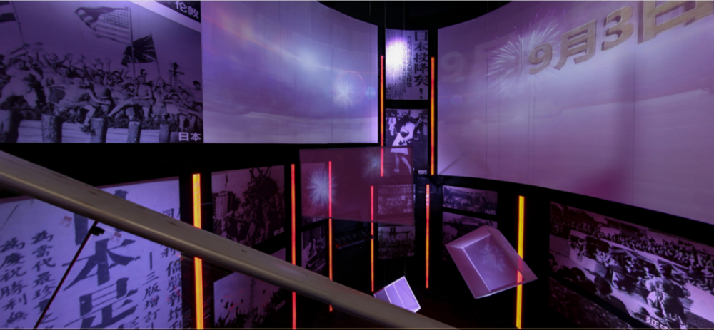 Figure 2: View from the Escalator in the Victory Exhibition Hall. The display highlights the date of Japanese surrender and celebrations around the world. From left to right, one can see photos from Japan, Taipei, Berlin, Moscow, New York, Shandong, and Yan’an. Screenshot taken from museum website on March 25, 2020.