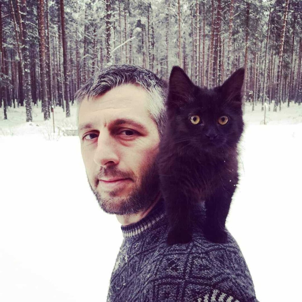 German Moyzhes pictured with a cat in a forest