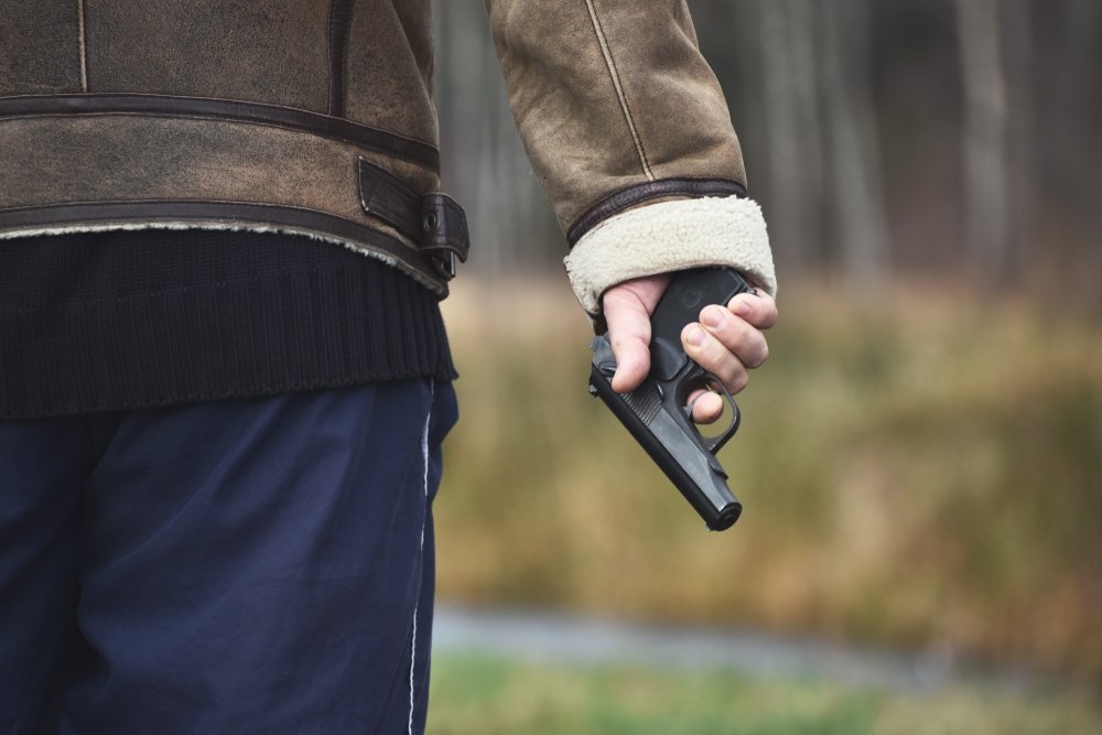 A hand holding a gun. 