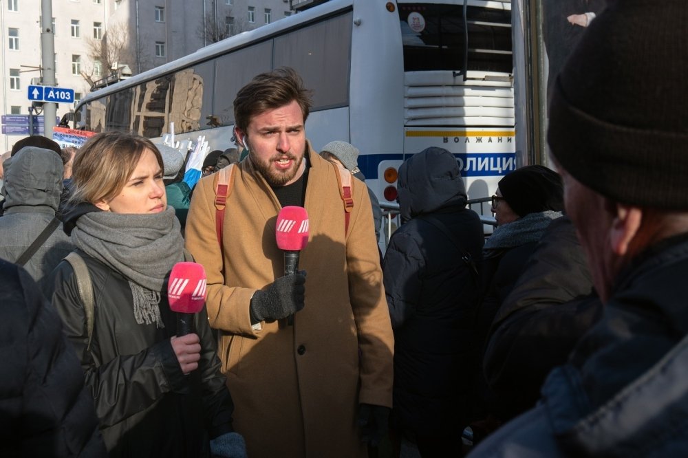 Image of two reporters with microphones 