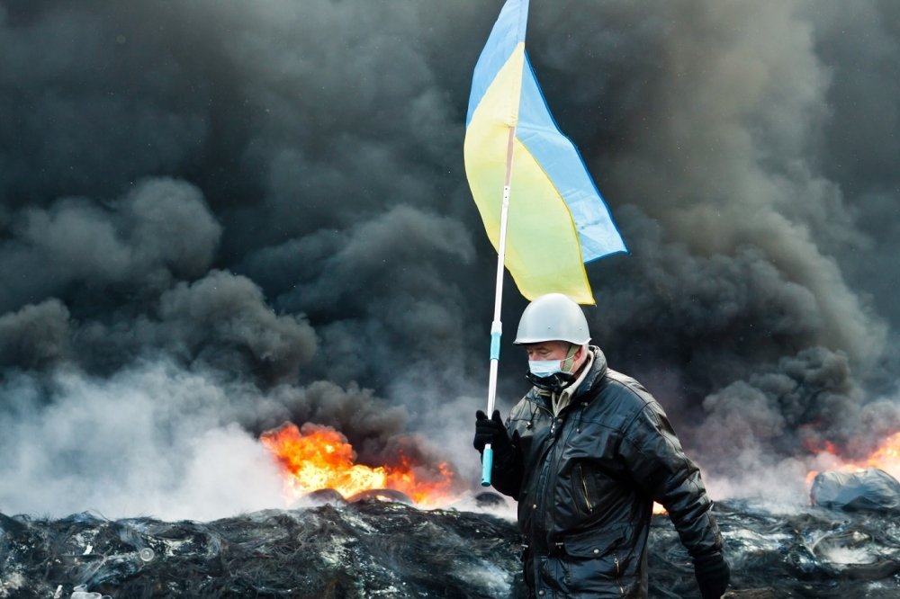 Unknown demonstrator carrying a Ukrainian flag at the Independence square in Kyiv during Euromaidan