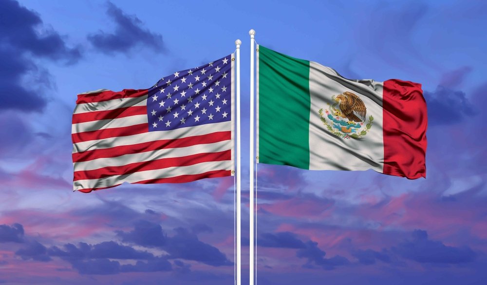 U.S. and Mexican flags at sunset