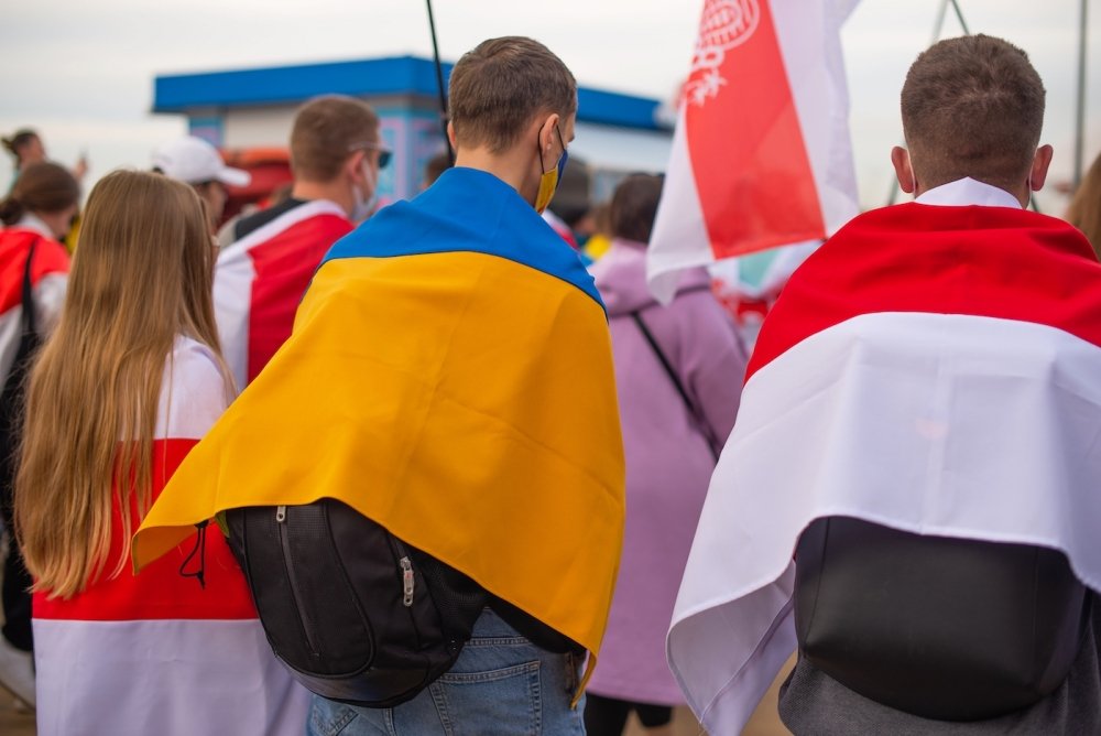 A group of protesters holding Ukrainian and Belorusian white and red flag