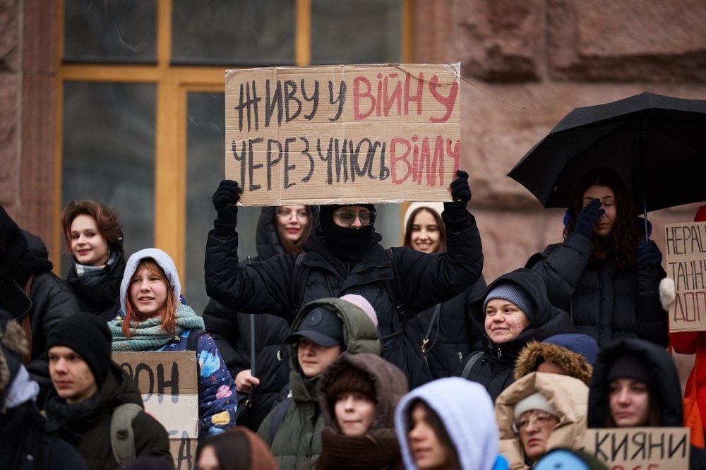 Young Ukrainian activists show a banner "I Live In A War Because of Someone's New Villa" on a protest against corruption in Ukraine