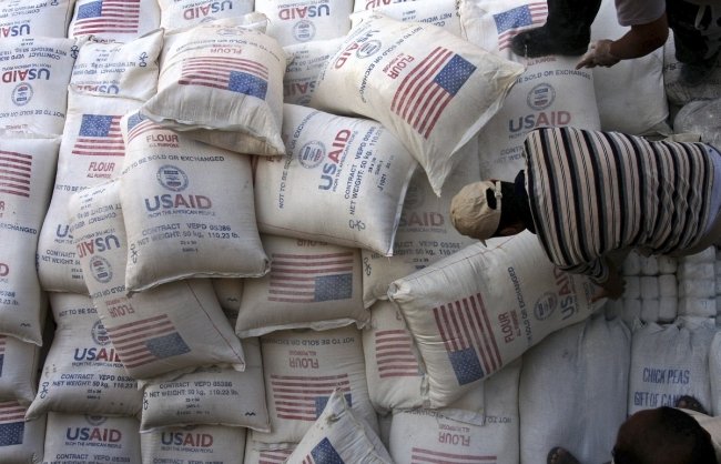 In this June 4, 2008 file photo, Palestinians unload bags of flour donated by the United States Agency for International Development, USAID, at a depot in the West Bank village of Anin near Jenin. AP Photo/Mohammed Ballas.