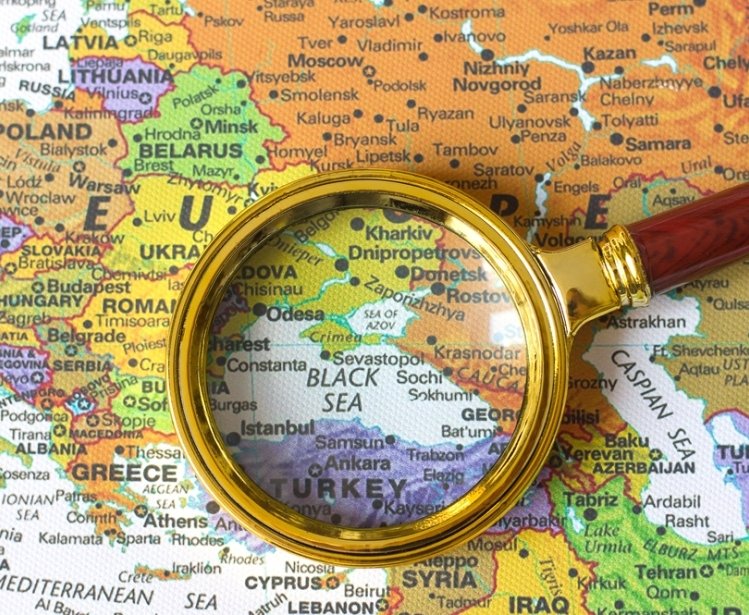 A looking glass centered over a map of the Black Sea.