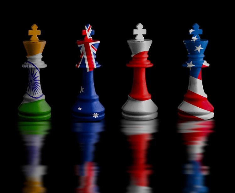 Four chess rooks with the flags of India, Australia, Japan, and the United States imprinted on them.