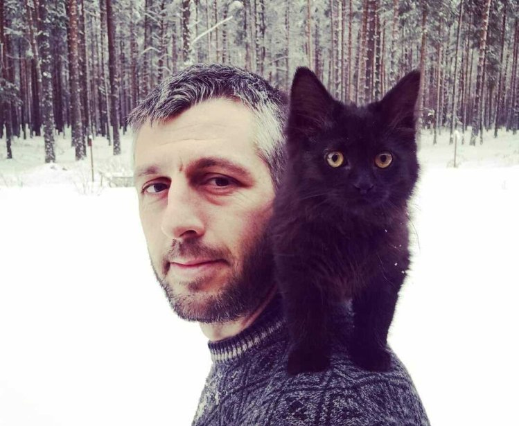 German Moyzhes pictured with a cat in a forest