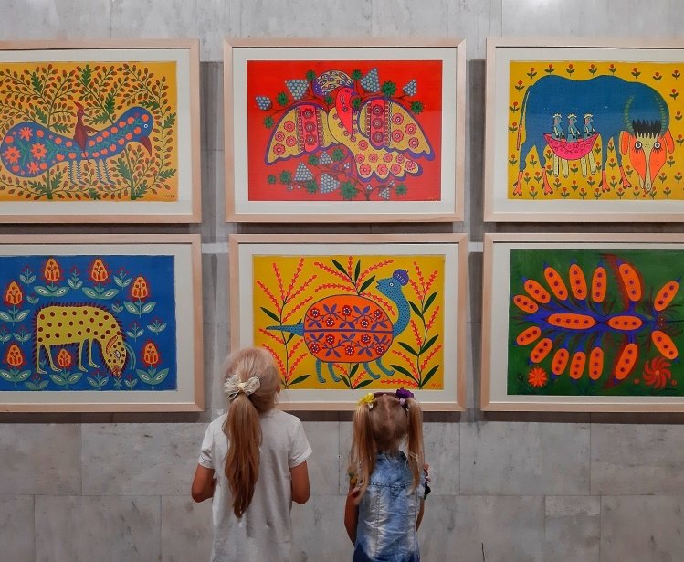 Two girls at an exhibition of paintings by Maria Prymachenko. 