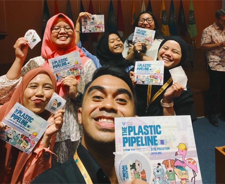Indonesian students and educators taking a selfie with the plastic pipeline brochures and sticker