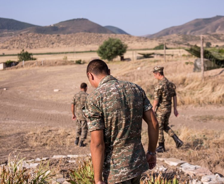 Nagorno-Karabakh, Republic of Artsakh - 08/03/2019 - Three soldiers of the Artsakh Defense Army walking on dirt road in their off time