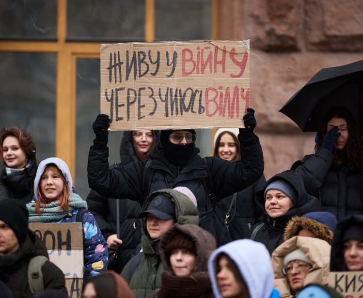 Young Ukrainian activists show a banner "I Live In A War Because of Someone's New Villa" on a protest against corruption in Ukraine