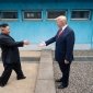 Chairman Kim Jong Un and President Donald Trump stand on either side of the DMZ border, reaching out to shake hands.