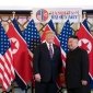 President Donald Trump stands with Chairman Kim Jong Un in front of the flags of the U.S. and North Korea