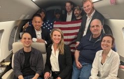 Americans detained in Russia pose on a plane on their way home