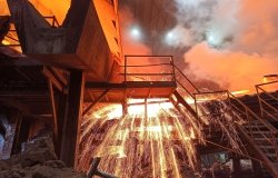 Sparks fly from a production smelter furnace.