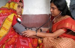 A woman health worker from a charity visited a house in a village to check the blood pressure of a pregnant mother as part of an antenatal checkup, Diamond Harbour, West Bengal.