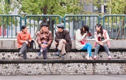 A group of people sit on a bench.